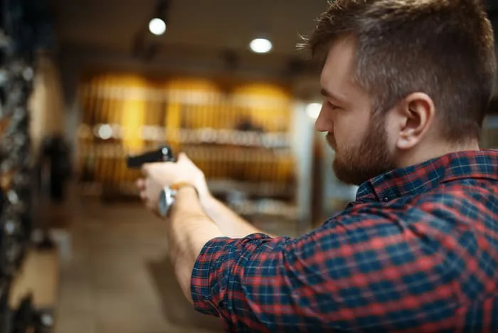 Man-aims-with-new-handgun-in-gun-shop