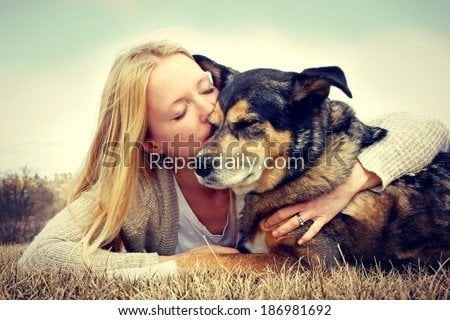 lady kissing pet dog