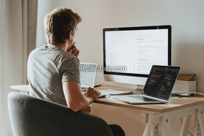 man infront of three computer laptops