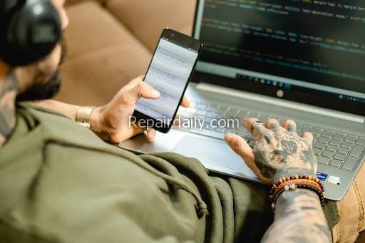 man working on laptop and mobile