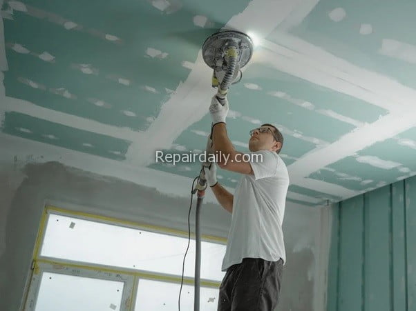 man painting ceiling home improvement
