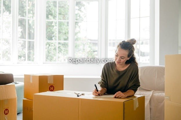 moving woman writing on boxes