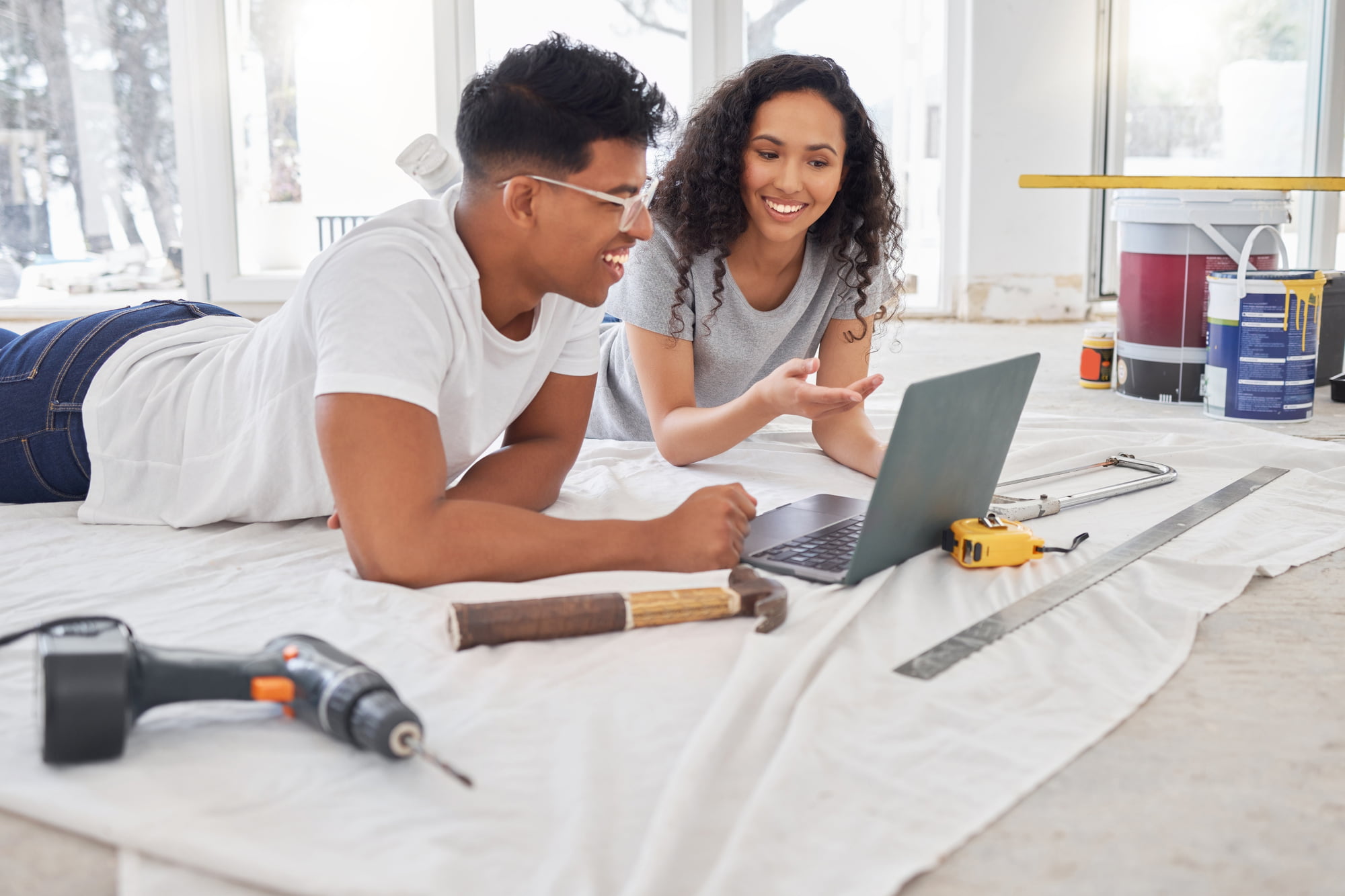 Laptop, renovation and diy planning with a couple in their new house together for remodeling design. Construction, real estate or property improvement with a man and woman discussing a home project
