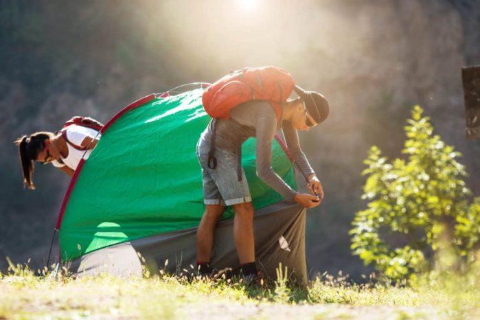 young couple setting up tent outdoorshiking and camping
