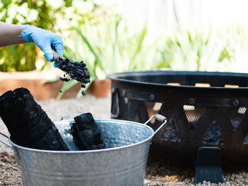 putting charcoal on fire pit